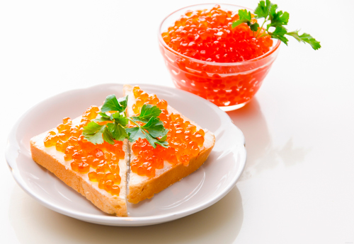 Веточка зелени украсит закуску из хлеба, масла и красной икры.