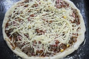 Домашняя пицца с фаршем: Посыпаем пиццу сыром