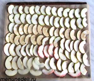 Порезанные тонкими дольками яблоки на противне перед помещение в духовку 