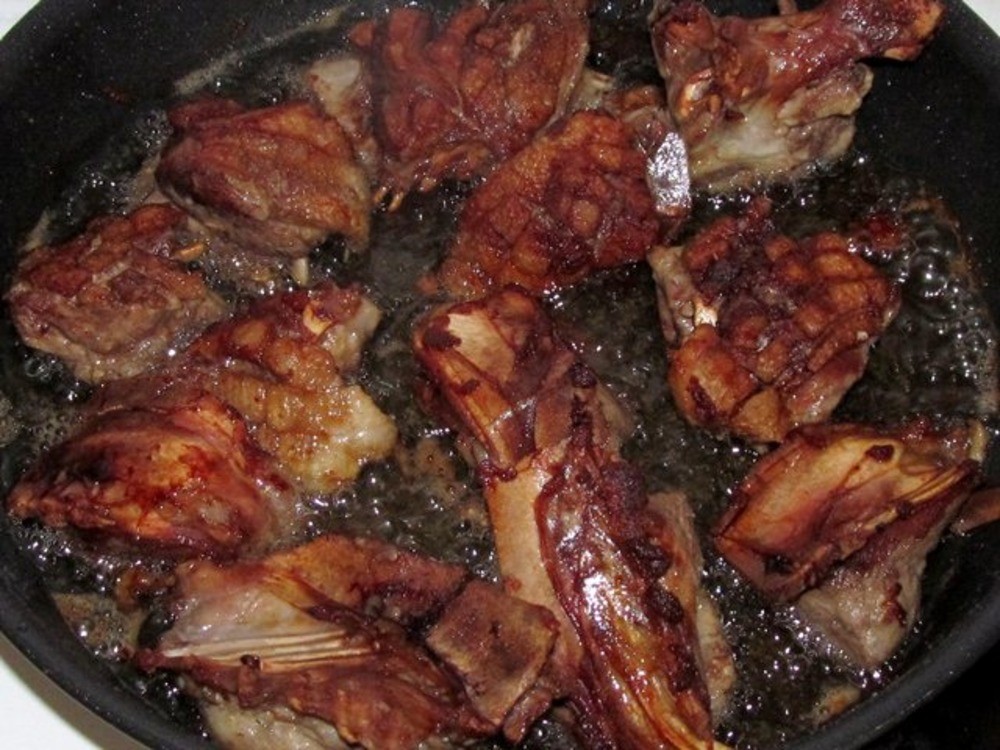 жареные кусочки мяса утки в сковороде с маслом